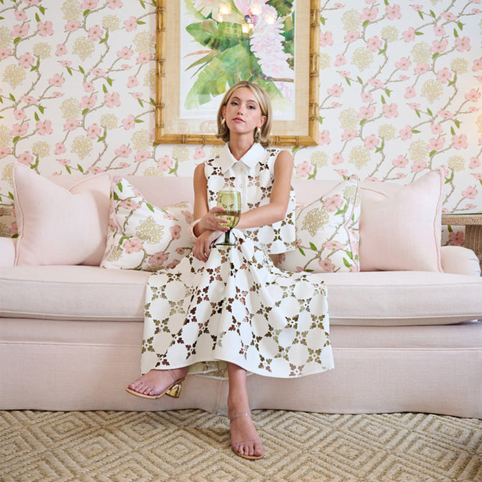 Woman sitting on a pink couch in a white laser cut leather set